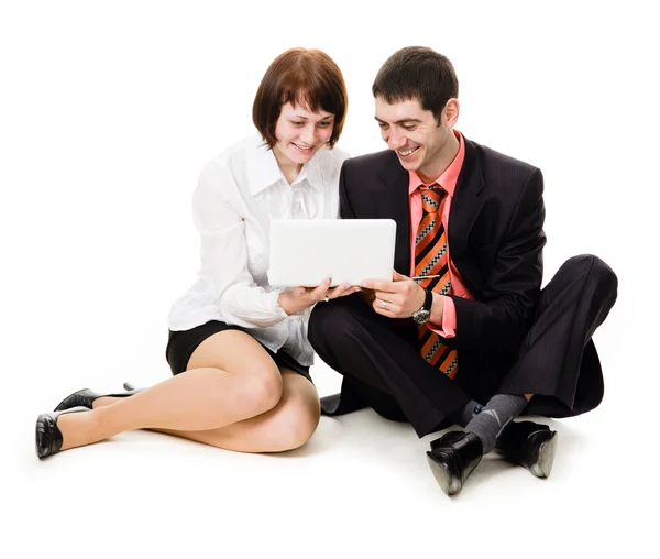Jovem e mulher sentados no chão, olhando para o laptop . — Fotografia de Stock