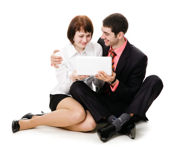 Mladý muž a žena sedí na podlaze a podívat se do noteb — Stock fotografie