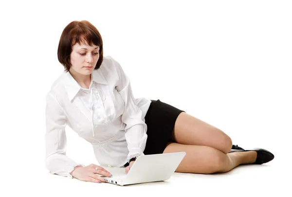 Katta oturan genç kadın ve saatler bir dizüstü bilgisayar. — Stok fotoğraf