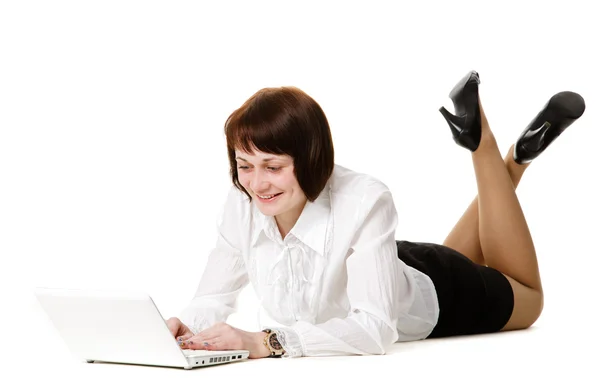 Jonge vrouw op de vloer liggen en werken op een laptop. — Stockfoto
