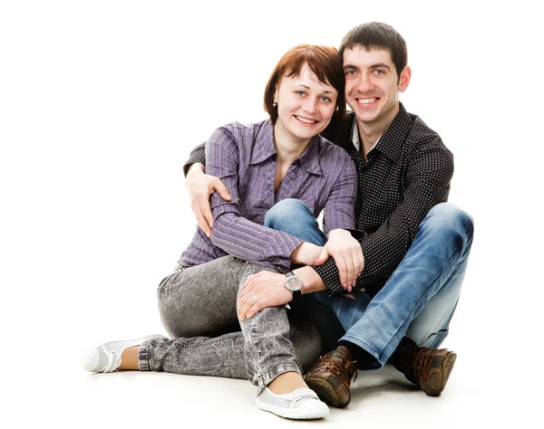 Jovem mulher e homem sentado no chão, um cara abraça uma menina . — Fotografia de Stock