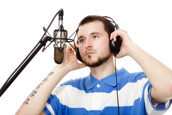 Ung kille med ett skägg, skriver en låt med hörlurar och en micr — Stockfoto