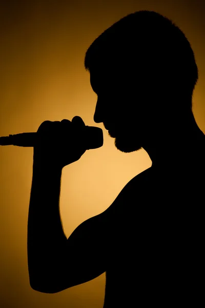 stock image Silhouette of a young man in orange.