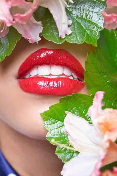 Fechar o rosto de uma mulher coberta de folhas e flores verdes — Fotografia de Stock