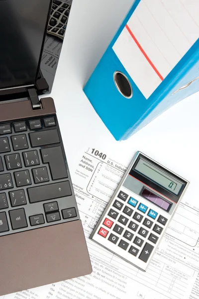 Formulario de impuestos, parte de la computadora portátil, calculadora, carpeta de la oficina y pluma — Foto de Stock