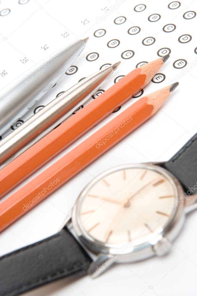 Blank answer sheet pencils, pens and watch - student prepare workplace to complete the examination