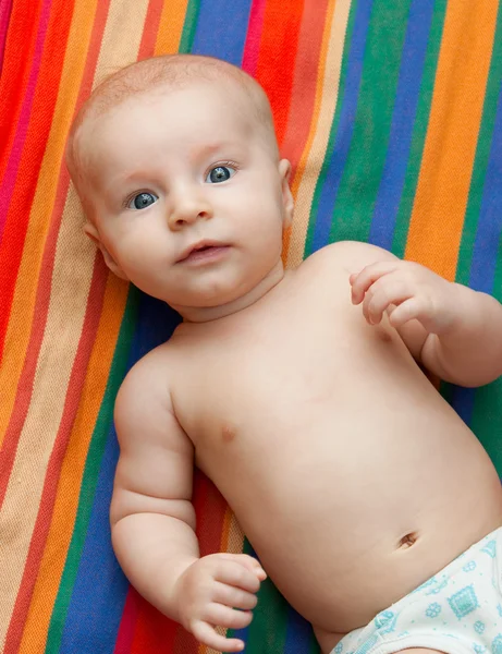 Baby liegt auf gestreiftem Hintergrund — Stockfoto