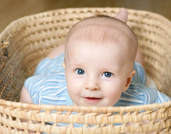 Маленький мальчик лежит в плетеной корзине — стоковое фото