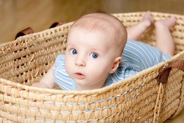 Sorprendido niñito acostado en canasta de mimbre — Foto de Stock