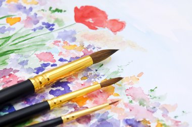 Paint brushes on watercolor backdrop clipart