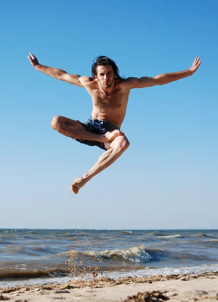 stock image Man jumping on the beach