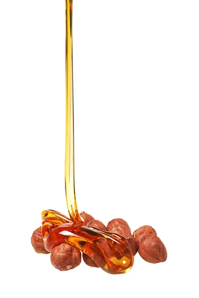 stock image The honey stream flows down on nuts