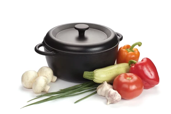 Black cast-iron cauldron with vegetables — Stock Photo, Image