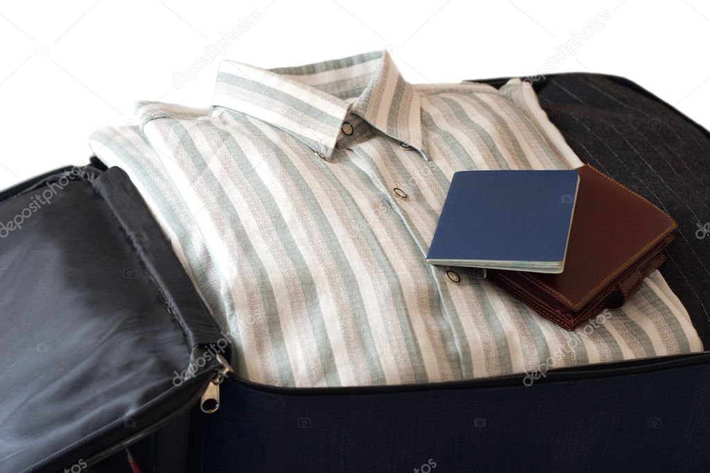 Clothes, wallet and passport in suitcase (isolatedon white backg