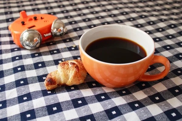 Morning - alarm clock, cup of coffee and croissant — Stock Photo, Image
