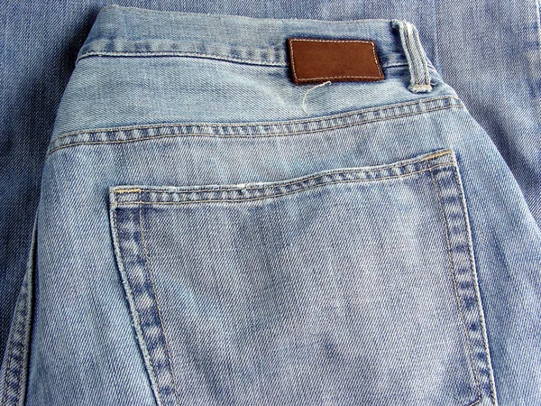 Blauwe katoenen jeans met een zak, als achtergrond — Stockfoto