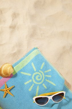 Beach concept with towel and sunglasses clipart