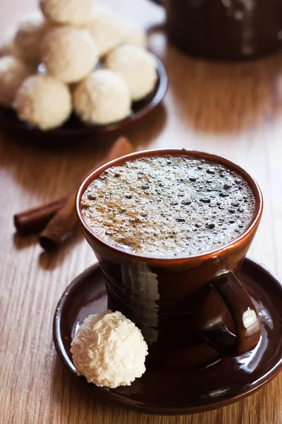 Filiżankę kawy i białe trufle czekoladowe na stole — Zdjęcie stockowe