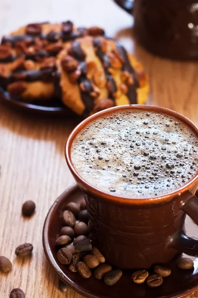 Чашка кофе и шоколадное печенье на столе — стоковое фото