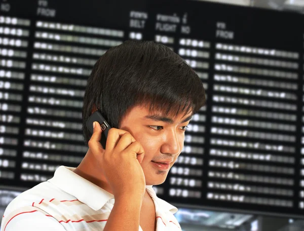 Людина розмовляє своїм мобільним телефоном в аеропорту — стокове фото