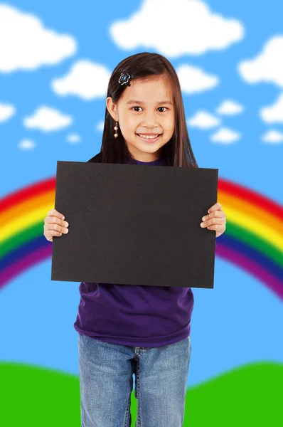 Una ragazza sorridente che tiene una tavola nera vuota — Foto Stock