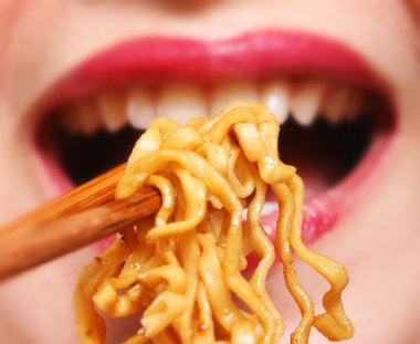 Young chinese woman eating noodles clipart