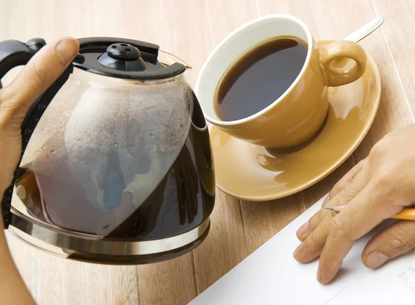Ein Mann gießt Kaffee in eine Tasse — Stockfoto