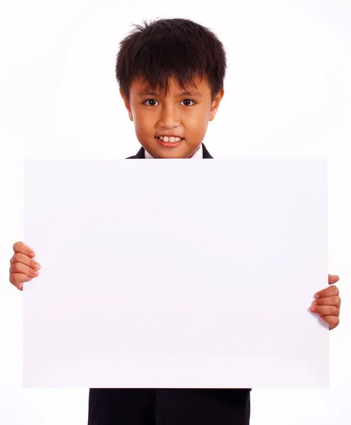 Fröhlicher Junge hält eine weiße Tafel in der Hand — Stockfoto