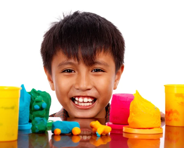 Szczęśliwy chłopiec bawi się kolorowe ciasto — Zdjęcie stockowe