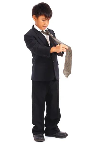 Jeune garçon en costume faisant son lien — Photo