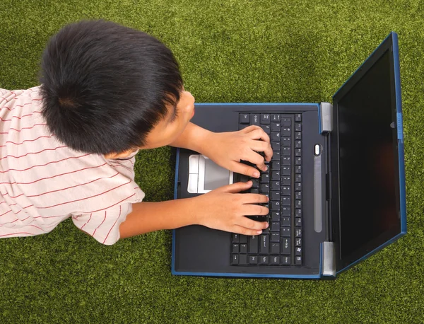 Jong kind met behulp van zijn zakboekje computer — Stockfoto