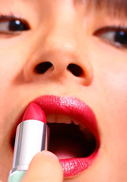 Raakt aan haar make up toe te voegen en toe te passen lippenstift — Stockfoto