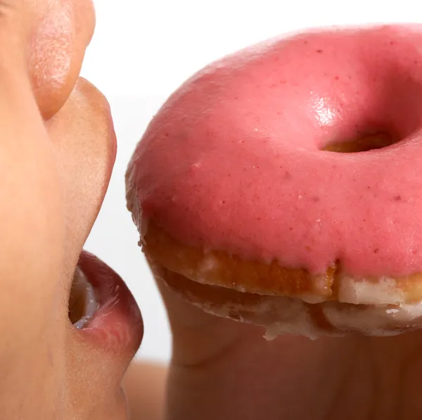 Een ongezonde donut eten — Stockfoto