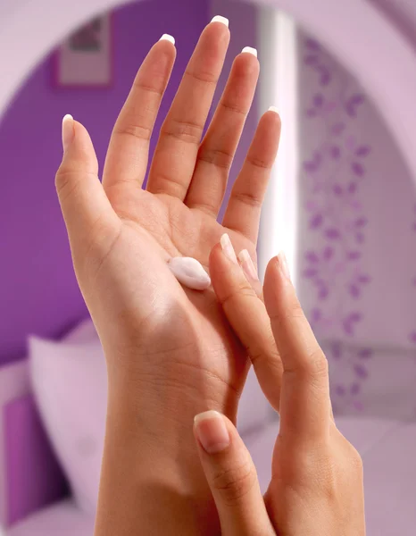 Vochtinbrengende crème zetten haar handen — Stockfoto