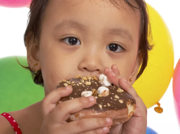 Παιδί τρώει ένα ντόνατ σε ένα πάρτι — Φωτογραφία Αρχείου