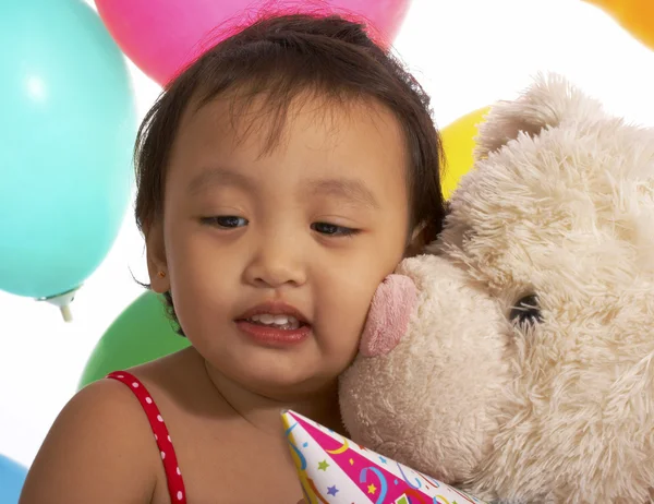 Mädchen bekommt Kuss von einem Teddybär — Stockfoto