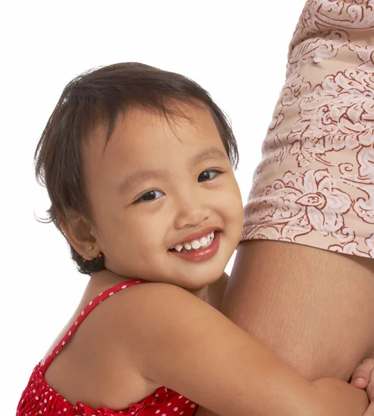 Liten flicka kramar hennes mors ben — Stockfoto
