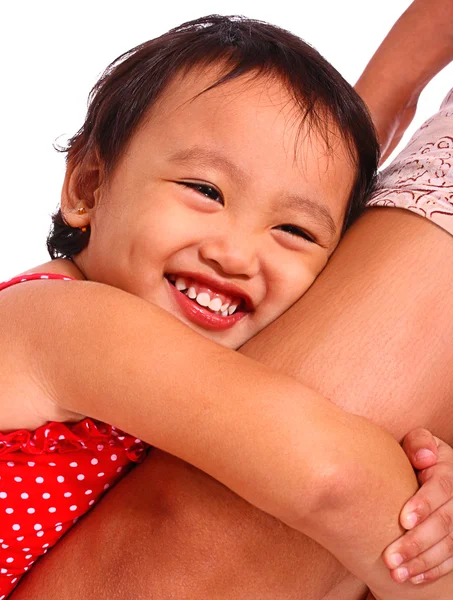 Menina sorridente feliz abraçando a perna de sua mãe — Fotografia de Stock