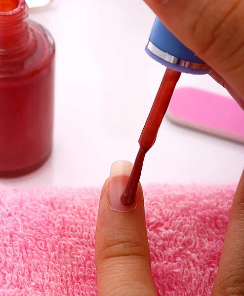 Mujer aplicando esmalte de uñas rojo a sus uñas —  Fotos de Stock