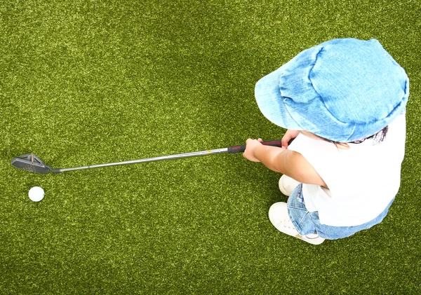 Criança pequena jogando golfe em um putting green — Fotografia de Stock