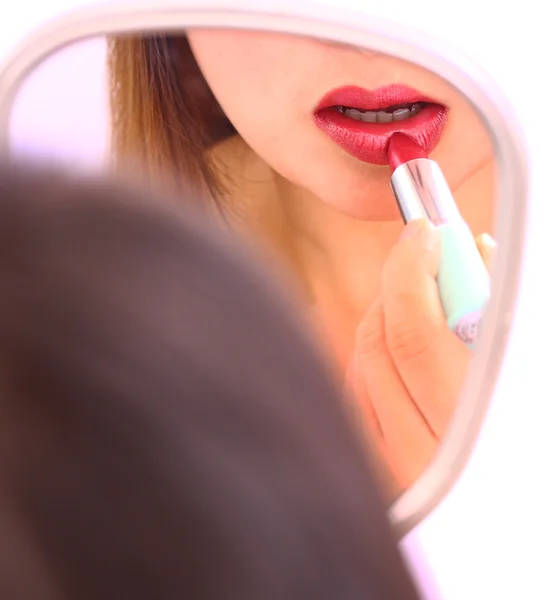 Regardant dans le miroir et appliquant rouge à lèvres rouge — Photo