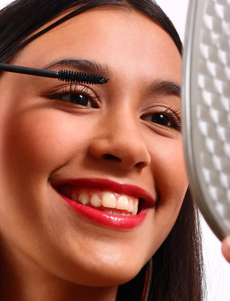 Glücklicher junger Teenager, der sich mit Mascara schminkt — Stockfoto