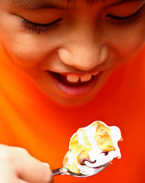 Мальчик, поедающий вкусный кремовый пирог — стоковое фото