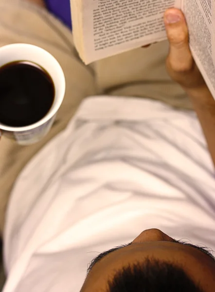 Lire un livre et boire une tasse de café — Photo
