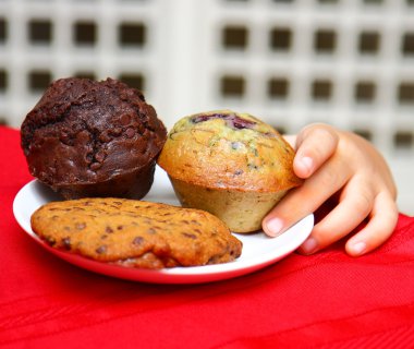 Çocuk bir muffin tablo çalmak