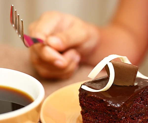Mangiare qualche torta al cioccolato con una tazza di caffè — Foto Stock