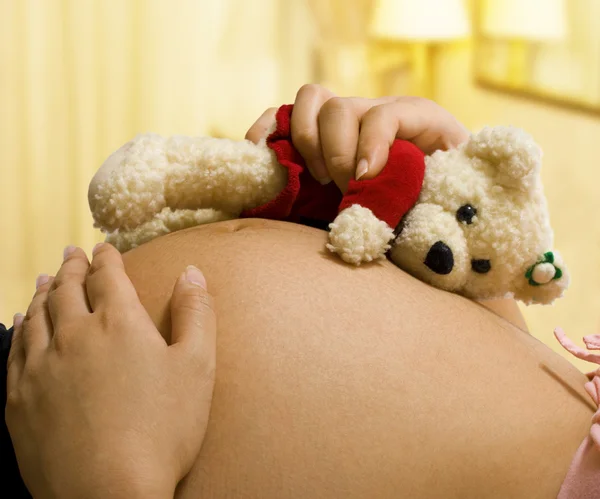 Werdende Mutter hält einen Teddybär in der Hand — Stockfoto