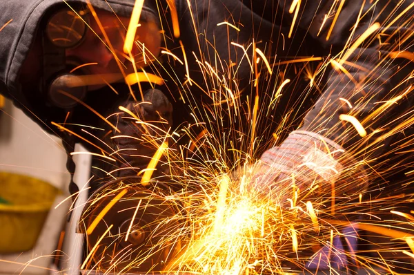 Werknemer snijden metaal met veel scherpe vonken — Stockfoto