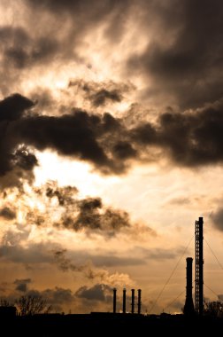 Silhouette of a power plant against evening sky clipart