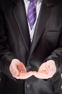 Groom holding the ring of marriage in his hands clipart